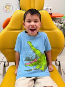 Child In Dinosaur Shirt Smiling
